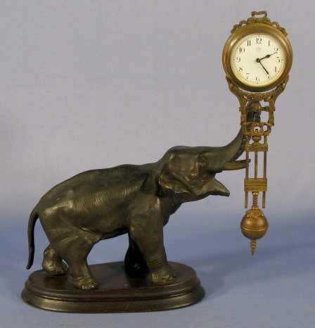Junghans Elephant Swing Clock: Junghans Elephant Swing Clock: the elephant is made of spelter and on a wood base. The fixed key wind movement has a 1 3/4" dial. (The back of the brass case is dented. The dial has some yellow discol