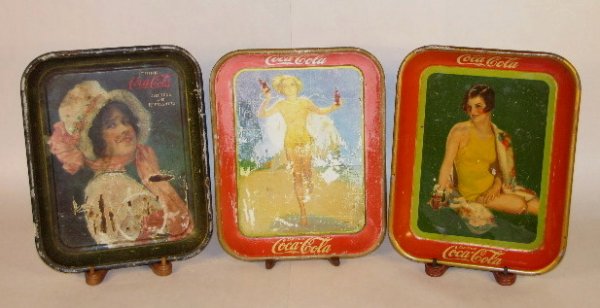 3 Tin Litho Coca Cola Serving Trays: 3 Tin Litho Coca Cola Serving Trays: 2 made by The American Art Works of Coshocton, Ohio. 1914, 1929 bottle sales & 1937. (All have problems.) 10 1/2" x 13 1/4" All items sell As Is, Where Is, no guar