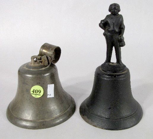 2 Bells, Cast Iron & Brass: 2 Bells: 1.) The hand held cast iron bell has a figural handle formed as a man wearing a short sleeve shirt, he holds something in his left hand; the other is one his hip. No makers info. 6 1/2" tall
