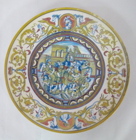 Pottery Plate w/Luster Decoration, Cherubs & More: Pottery Plate w/Luster Decorations: around the border are cherubs with winged horse/serpents and portraits along with torches and scrolling floral designs. The center scene is what looks like a scene 