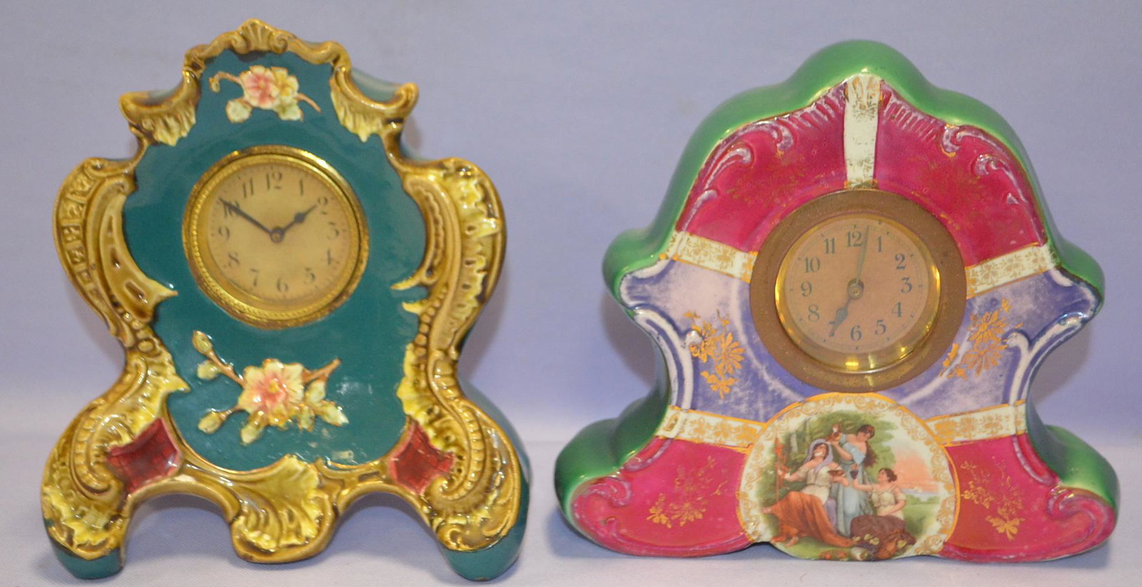 Lot of 2 Small Porcelain Mantel Clock: Lot of 2 Small Porcelain Mantel Clock. 1.) New Haven, signed dial. Blue, brown, floral design. Porcelain clock. 7" x 6". 2.) Multi-color with portrait on front women drinking wine.. Porcelain clock, t