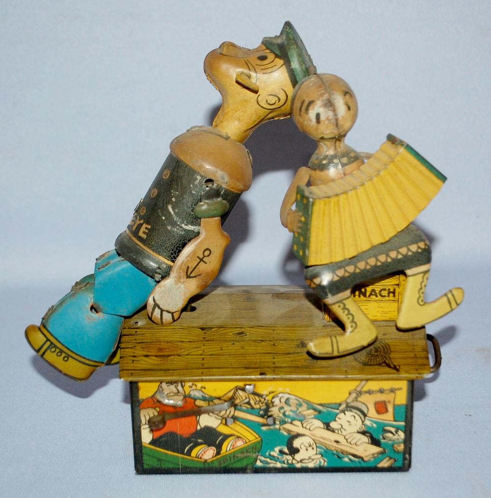 Antique Marx Popeye & Olive Oyl Tin Litho Wind Up Toy:: Antique Marx Popeye & Olive Oyl Tin Litho Wind Up Toy: they sit on a building decorated with related cartoon characters. Olive plays an accordion; in working condition; may need oiled. (There is some 
