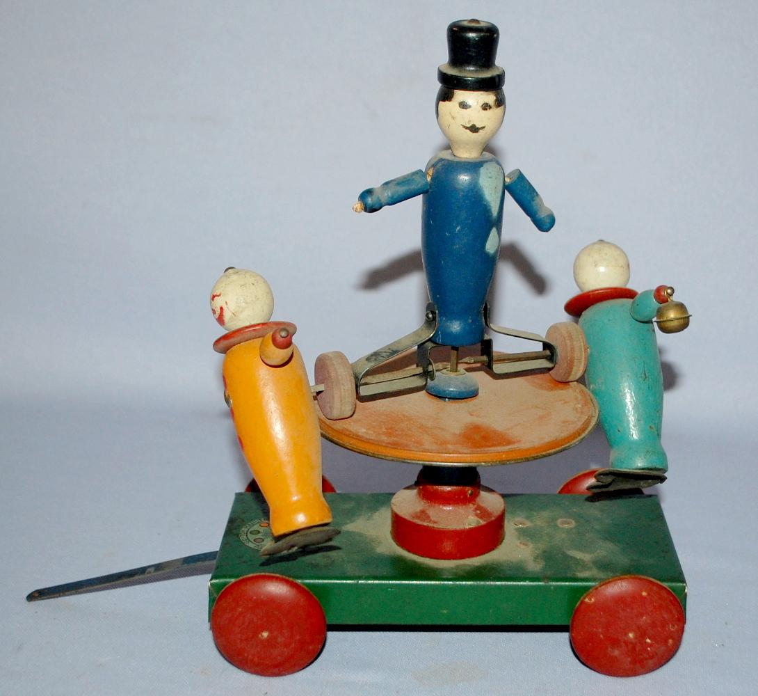 Vintage Wood & Metal Pull Toy by The Go-Toy Mfg: Go-Toy: Vintage Wood & Metal Pull Toy by The Go-Toy Mfg: Go-Toy Mfg of Brooklyn N.Y.. A central figure and 2 side figures spin and go around the edge when pulled or pushed. (Several small balls are missing; t