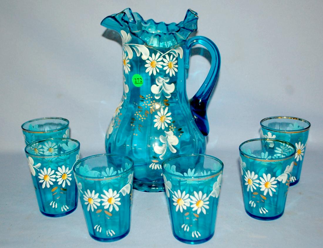 7 Piece Enameled Blue Glass Water Set: Pitcher and 6: 7 Piece Enameled Blue Glass Water Set: Pitcher and 6 tumblers; ruffled and crimped rim; applied blue handle; all are decorated with enameled white daisies. (Gold wear on tumbler rims.) Tallest 10 7/8"