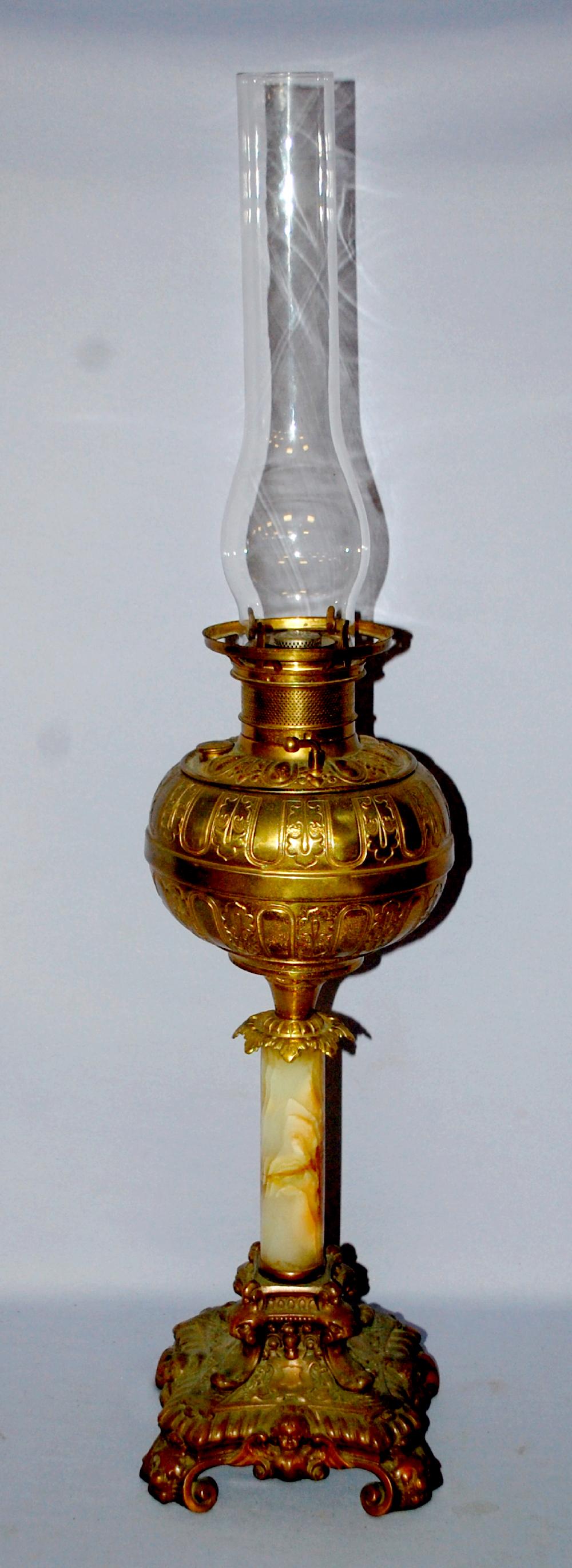 Antique Marble Stem Rayo Kerosene Lamp. Metal cherub: Antique Marble Stem Rayo Kerosene Lamp. Metal cherub base, marble or onyx stem, metal font; Rayo burner; Fuel cap marked "The Meriden", has chimney. The globe rim is a little out of round shape. 20 1/