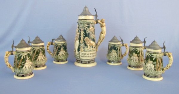 7pc. Teddy Roosevelt Safari Pottery Steins: German 7pc. African Theme Pottery Steins: molded pottery in relief African animals and a hunter in an elephant Hudah. A lion is attacking the hunter. There are other lions, leopards and tropical trees