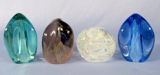 4 Modern Studio Glass Paperweights: 4 Modern Studio Glass Paperweights: 1.) Clear with non uniform air bubbles and slight bit of aventurine. Signed Karc. 3" tall 2.) One each blue, green and amethyst by Gilbert Johnson 1985 and 1988. Th