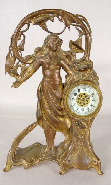 J.B. Metal Art Nouveau Lady Clock: J.B. Metal Art Nouveau Lady Clock: lady standing by clock with arch of trumpet shaped flowers over her head; base marked "J.B. Signifies the Best"; dial marked New Haven Clock Co. (Back of clock dial