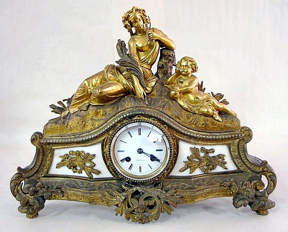French Dore & Bronze Mantle Clock: French Dore & Bronze Mantle Clock: with a time and bell striking movement and 3 3/4" porcelain dial. Wording on the dial is worn. The case has ornamental marble in the front. (There is no pendulum but