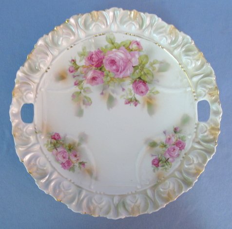 Unmarked RS Prussia Molded Cake Plate: Unmarked RS Prussia Molded Cake Plate: green with pink roses. Ring on bottom. Pattern not found in book, tulip like edge with center swag. (Chip near 1 handle.) 9 1/2" All items sell As Is, Where Is, 