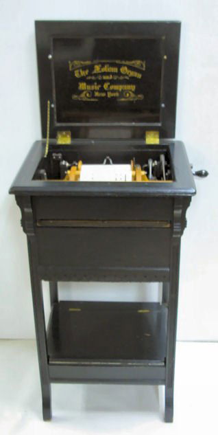 Aeolian Organ & Music Co. Musical Stand Organette: Aeolian Organ & Music Company, New York Musical Boudoir Stand Organette: Pat. Jan. 1886. Lift to floor cabinet, painted black with lift top. Roll storage on bottom section. Lid has naugahyde pad on th