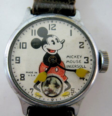 Ingersoll Mickey Mouse Wrist Watch: Ingersoll Mickey Mouse Wrist Watch w/Band: serial no.A1616655; Pat. Dates 1918 & 1922. His arms are time indicators; there are 3 figures on the seconds disc. The leather band has a metal Mickey on bot