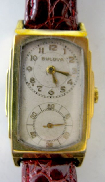 Bulova Double Dial 17J 10K GF Wrist Watch: Bulova Double Dial 17J 10K GF Wrist Watch: marked on works; 17J; unadjusted; Swiss; 13AB; serial no.741615. In a Bulova 10K gold filled hinged case, numbered 445195. Ivory colored dial with gold numbe