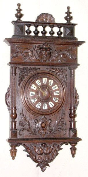 Carved Black Forest Wall Clock: Carved Black Forest Wall Clock: time and gong striking with a 7" wooden dial and painted Roman numerals. The case has a man of the north face near the top. The strike runs continuously when activated.