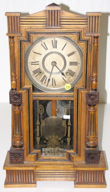 Gilbert Mitra 8 Day Mantle Clock: Gilbert Mitra 8 Day Mantle Clock: time with half hour gong striking movement and 7" dial. The ash case has darkened highlights. There is a partial, but legible label on the back. (The dial is worn and