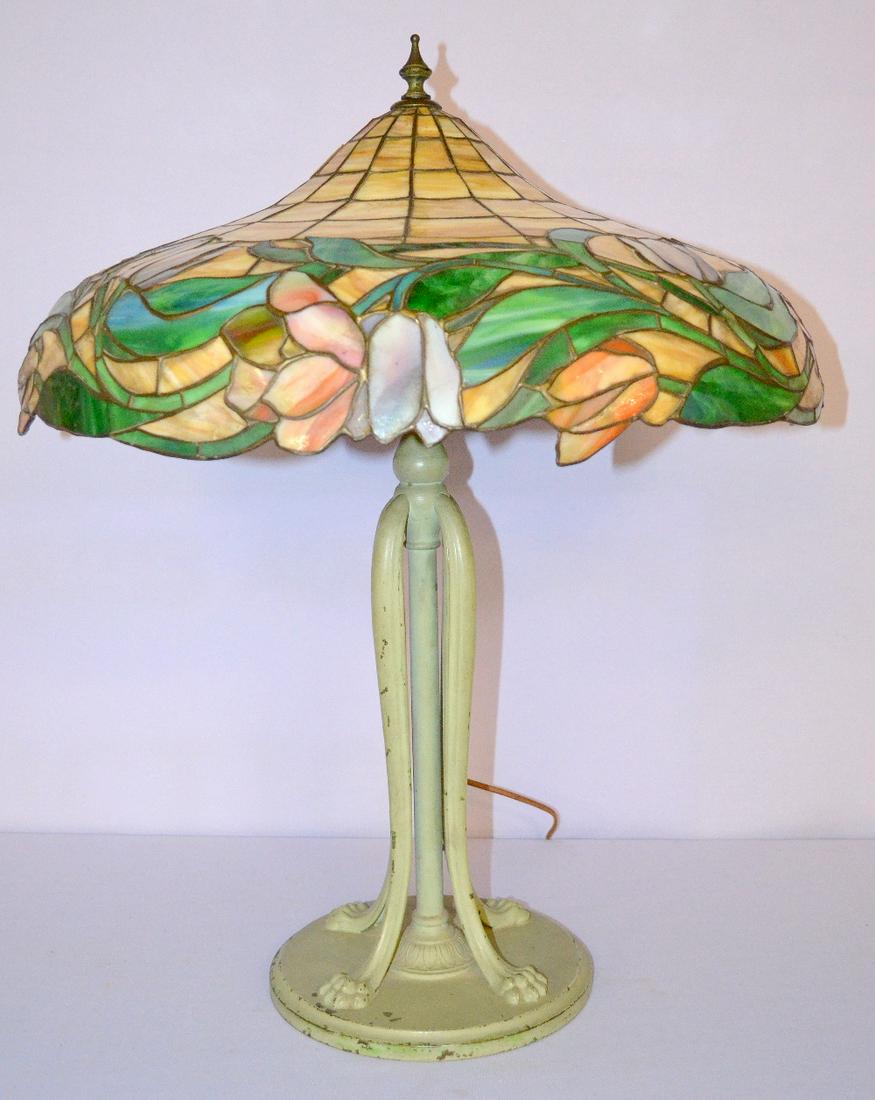 Antique Williams Chicago Leaded Glass Lamp: Antique Williams Chicago Leaded Glass Lamp. Electric, 4 claw foot on circular base, painted triple socket legs. Bell shaped shad has multi-colored tulepot leavers. 20 1/2" D. Minor cracks attributed t