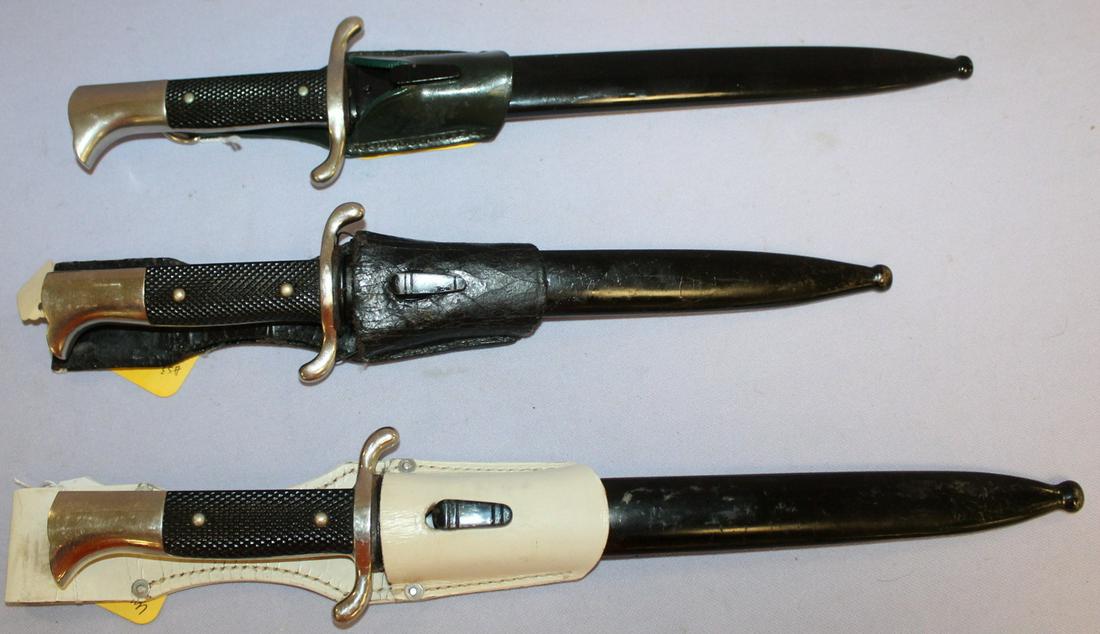 3 German WWII Fire Service Dress Bayonets in Scabbards: 3 German WWII Fire Service Dress Bayonets in Scabbards, with leather one on a white leather belt hanger and is in black. The bayonets are 14 3/4" long. The blades are well preserved.