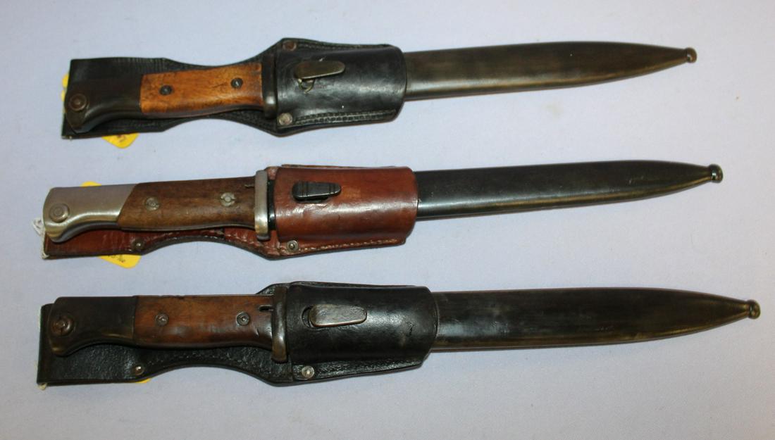 3 German WWII Bayonets with Scabbards and Leather: 3 German WWII Bayonets with Scabbards and Leather Hangers. 1- M1914 that is 15" long. 2- 584198 circa 1943 marked M over 2580 in matching scabbard. 14 1/2" long. 3- 584198 by Carl Eickhorn 1937. Seria