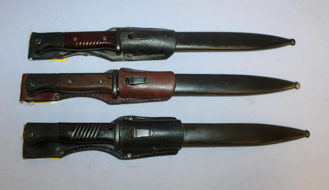 3 German WWII S84/98 Bayonets with Scabbards: 3 German WWII S84/98 Bayonets with Scabbards and one leather belt hangers. One by Elite Diamond; another by WKC No. 8241; Last is by BYM No. 81804 over 410. 2 are 15 1/8" long, one is 15" long. All bl