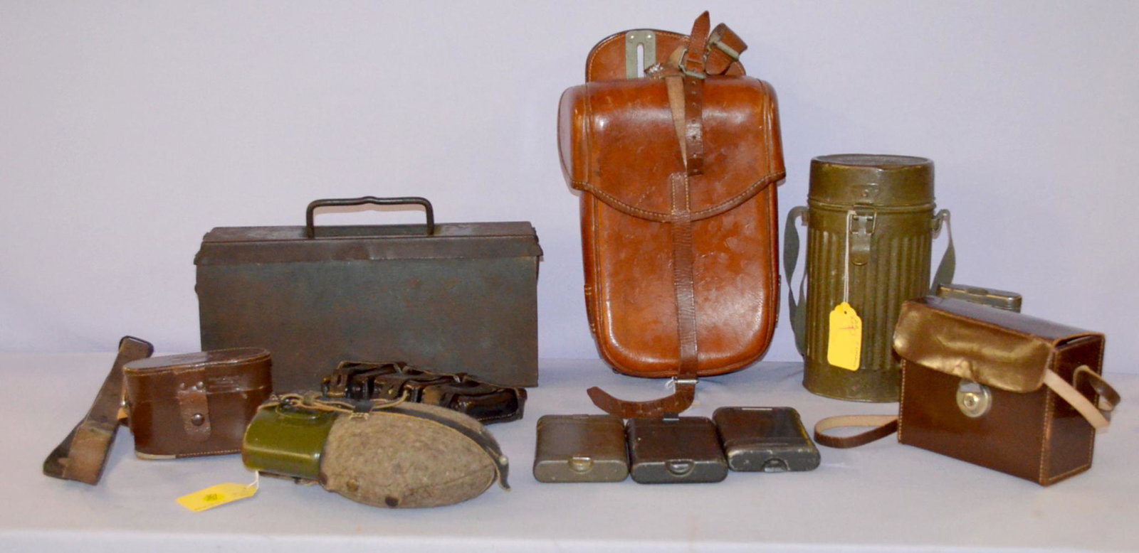 Ten German Military Items: Ten German military items. 1- model 1931 canteen, complete with cover, 8 1/2" long. 2- WW2 3 pouch ammo holder for the belt, 8 3/4" W by 4". 3- Single leather saddlebag marked LLG soligen 1941, it is 