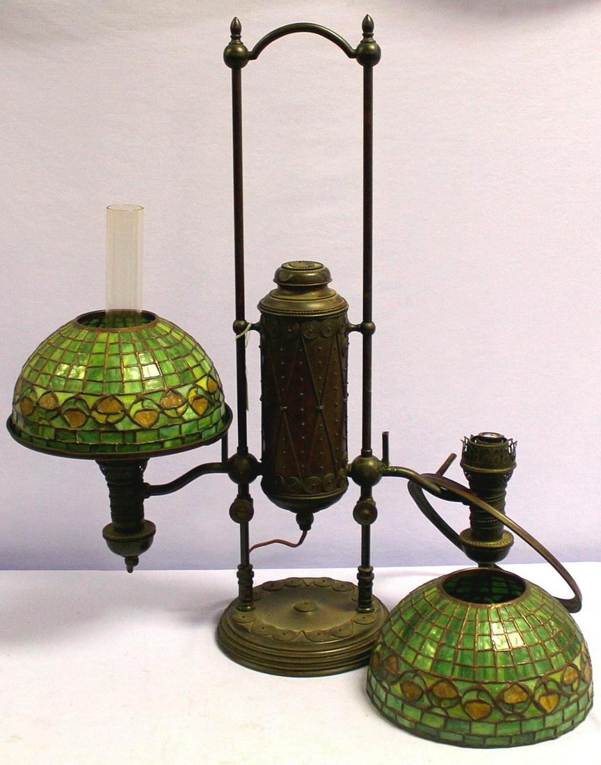 Antique Tiffany Dual Student Lamp: Antique Tiffany Dual Student Lamp, w/ scroll work motif and arabesque window on the centeral canister, Manhattan Brass Co. Spiral tubes 1870's. Scroll pattern worked base, 2 green leaded glass vine sh