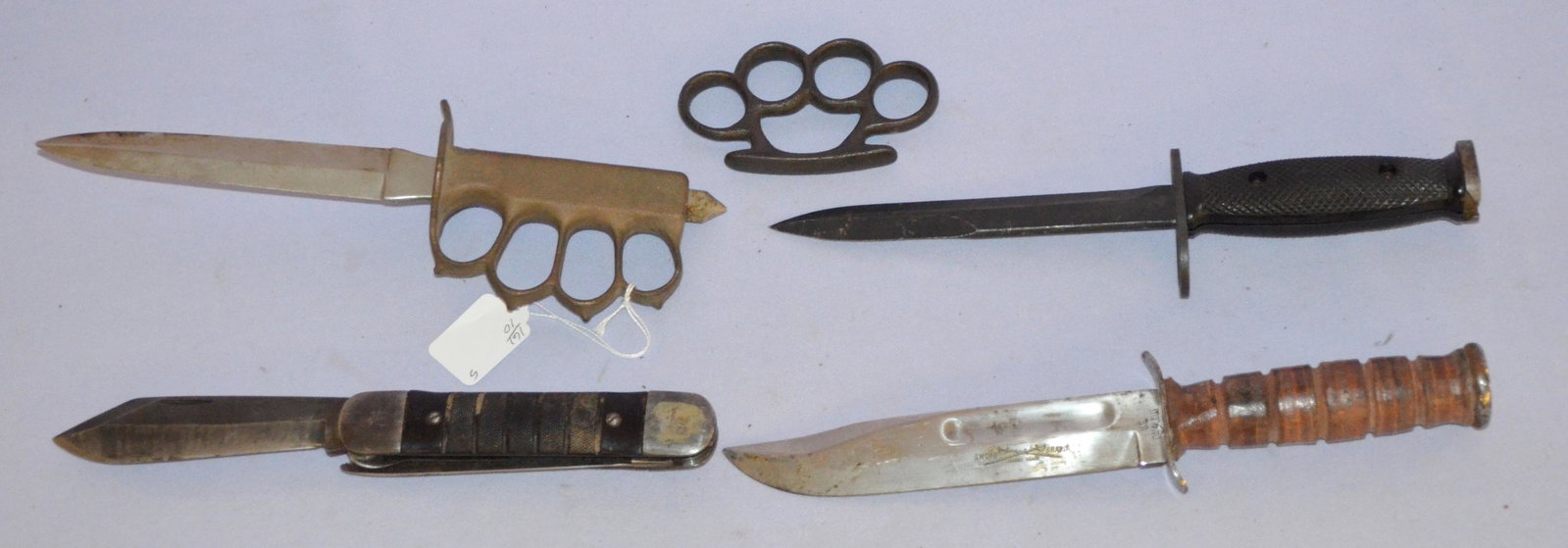 Military and other knives and knuckles: 1- U.S. M7 MILPAR bayonet 11 1/4" 2- Navy survival kit knife marked colonial Prov. RI on the blade. Overall length 10 5/8" - shows some use. 3- US 1918 trench knife. No scabbard. Length 11 1/2". 4- Ca