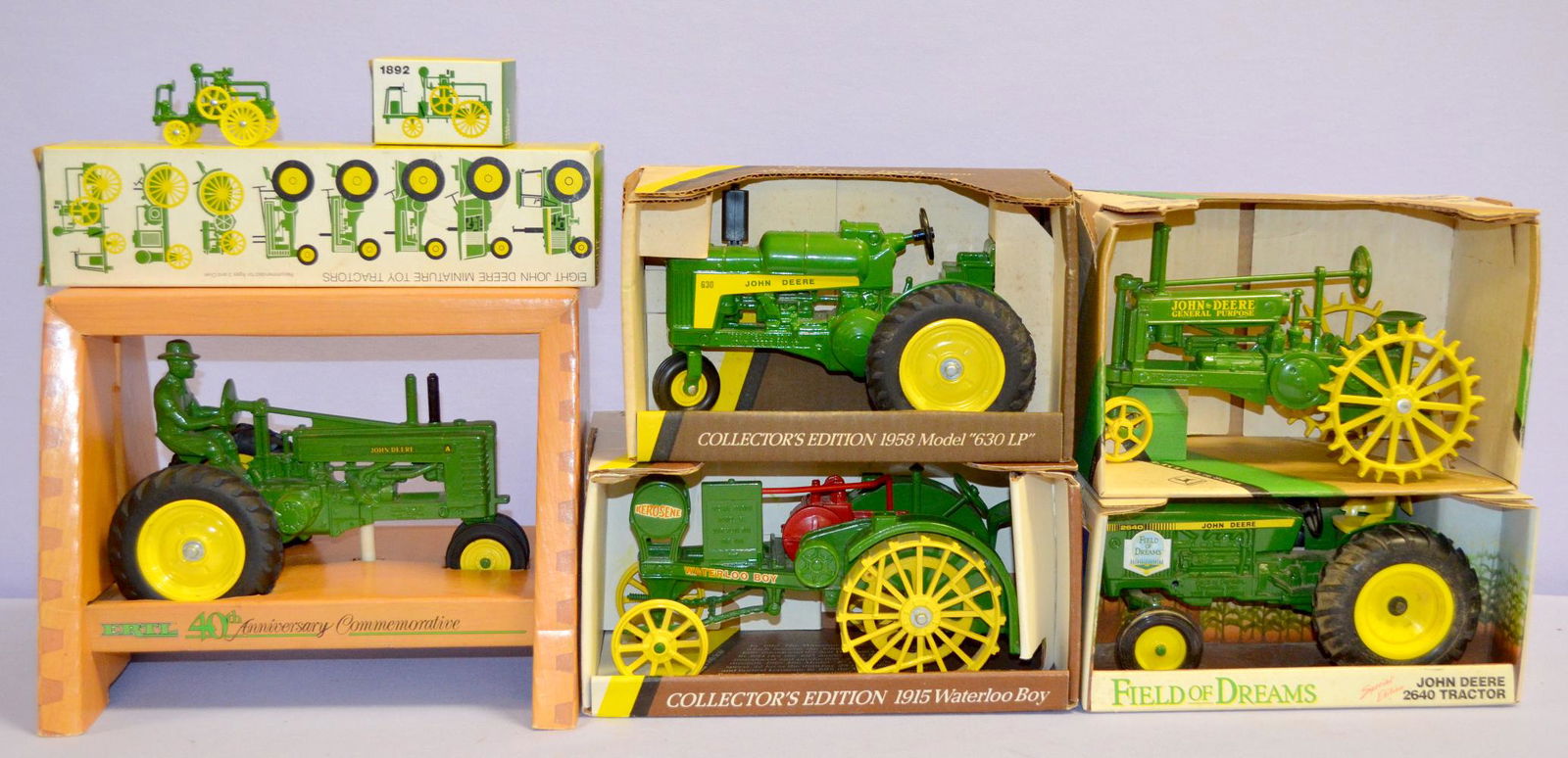 6 Ertl John Deere toy tractors in boxes: 6 Ertl John Deere toy tractors in boxes. 1- 1915 Waterloo boy. 2- GD general purpose. 3- 2640 field of dreams. 4- 1958 model '63 LP'. 5- 40th ann. 6- set of 8 minis