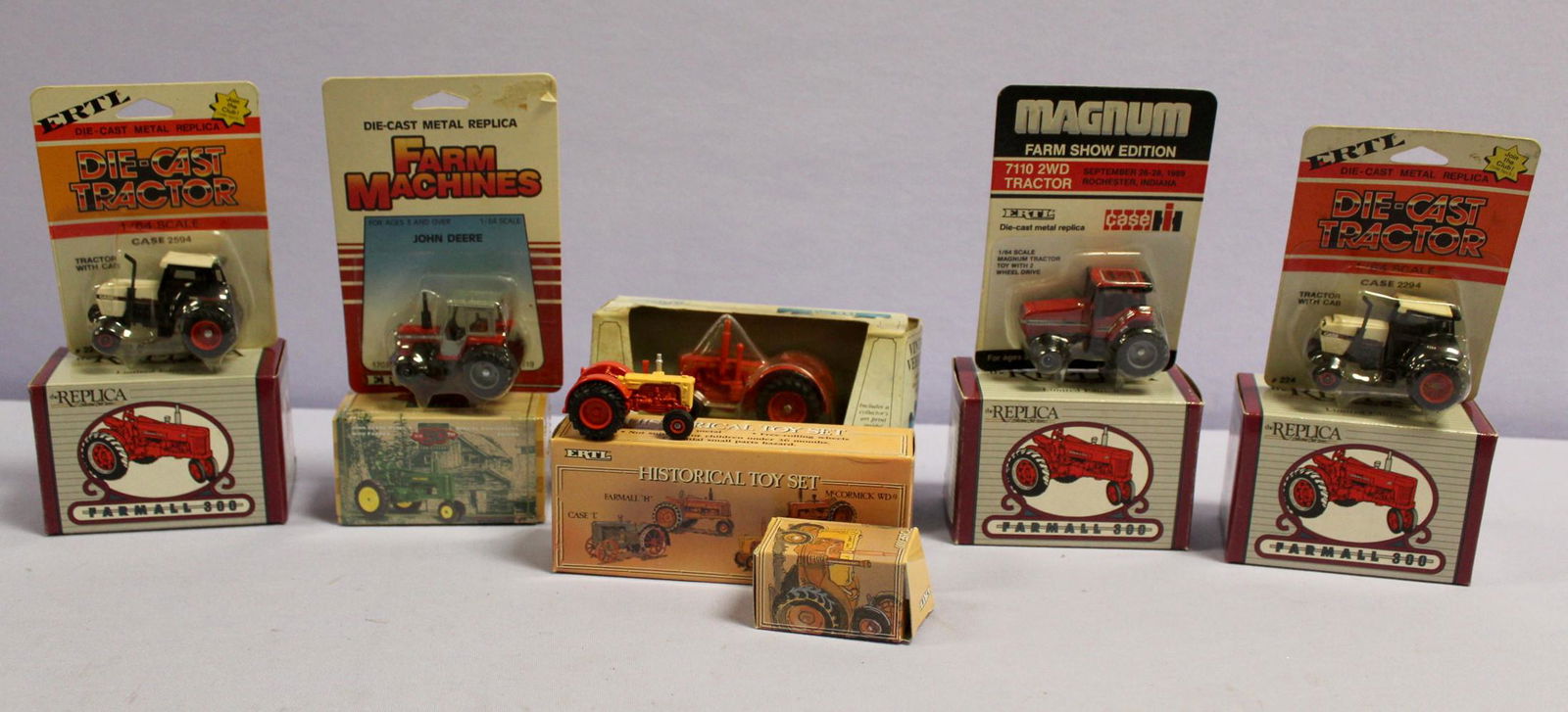 10 ERTL die-cast toy tractor in boxes: 10 ERTL die-cast toy tractor in boxes. 1991 formall 300. 3- 1995 john deere 50th ann. Historical toy set. Case 500. 2- case 2594. 7110 2WD. Massey fergerson 699, 1986.