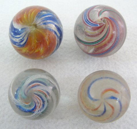 4 Onionskin, Latticino & Solid Core Marbles: 4 Onionskin, Latticino & Solid Core Marbles: all have original pontils. 1.) The onionskin has blue and white with red and yellow colors. 1.5" (With surface dings.) 2.) Red and white candy stripe solid