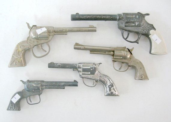 5 Metal Toy Cap Shooters: 5 Metal Toy Cap Shooters: 1.) Pony with eagle emblem on the grip. 2.) Pet with machined grips. 3.) Unmarked white metal. 4.) Tex with longhorn on the grips. (Finish worn) 5.) Sheriff with white plasti