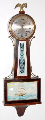 New Haven Mahogany Banjo Clock: New Haven Mahogany Banjo Clock: 8 day time with half hour gong strike and a silvered dial. In a mahogany case. With key. (The brass decorations on the sides are both broken.) 32" long and running at t