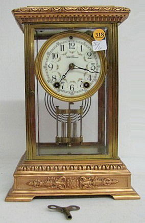 Seth Thomas "Empire No.18" Crystal Regulator: Seth Thomas "Empire No.18" Crystal Regulator: 8 day time with gong strike and a 4 1/2" floral dial. Copper colored and brass case with beveled glass on all sides. With a key. 12" tall and running at t