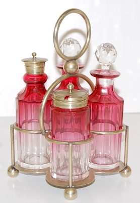 Cranberry 4 Bottle Condiment Set: Cranberry 4 Bottle Condiment Set: silverplate base marked HC & Co. S 1000; 4 unmarked paneled bottled, 2 with faceted stoppers, bottles shade from light pink to cranberry from the bottoms up. (Shaker 
