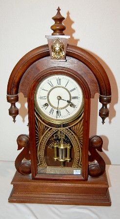 New Haven Parisian Walnut Mantle Clock: New Haven Parisian Walnut Mantle Clock: 8 day time with half hour gong strike and a 6" dial. The case has a partially legible label on the back. With key. (The backboard has a separation.) 24" and run
