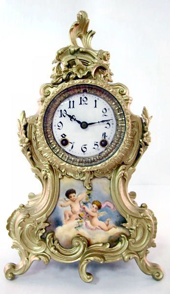 Ansonia "Amphion" Mantle Clock: Ansonia "Amphion" Mantle Clock: 8 day time with half hour gong strike and a 4 1/4" porcelain inset, decorated with hand painted winged cherubs. Artist name is partially visible. (Not running, both spr