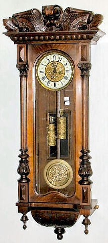 Gustav Becker 2 Wt. Hanging Regulator: Gustav Becker 2 Wt. Hanging Regulator: serial no.192983. The 7" ivorined dial has a decorated brass center that matches the pendulum ball and weights. In a mahogany case with carved decorations. (No k