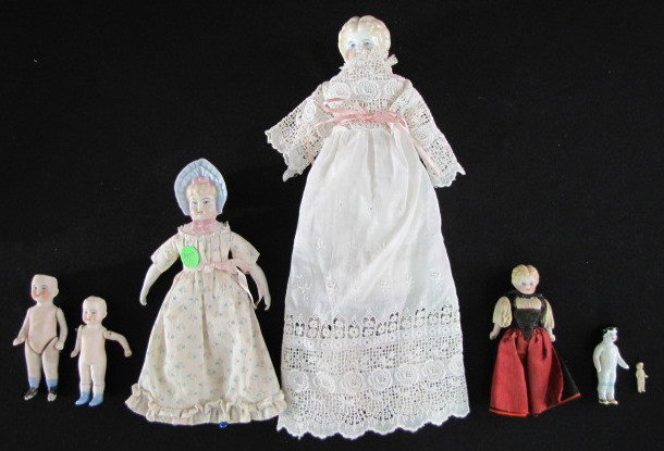 7 Antique China & Bisque Dolls: 7 Antique China & Bisque Dolls: 1.) Blonde china head marked O on back shoulder plate, low brow with painted features; new body, mismatched feet. 2.) Contemporary Parian head doll with bonnet and pain