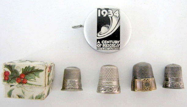 4 Sterling Thimbles & 1934 Tape Measure: 4 Sterling Thimbles & 1934 Tape Measure: 1.) Thimble marked gold and sterling with an anchor and size 12. 2.) Size 9 & 10 thimbles with floral engravings. 3.) Size 8 thimble in a Christmas box with ho