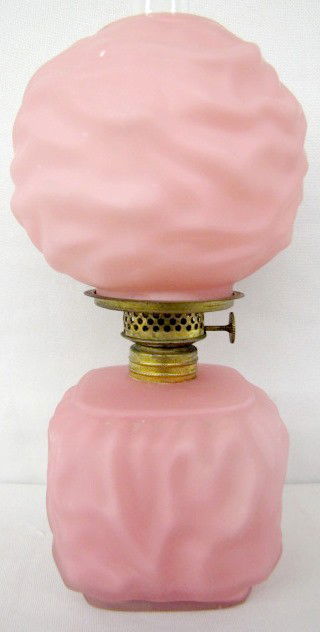 Miniature Pink Cased Ripple Kerosene Lamp: Miniature Pink Cased Ripple Kerosene Lamp: an old burner and ball shade are with it. (The ball shade's bottom edge has chips, hidden when in place.) 8 1/4" All items sell As Is, Where Is, no guarantee