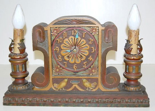 Seth Thomas Carved Case Candle Lamp Clock: Seth Thomas Carved Case Candle Lamp Clock: half hour and hour gong strike; has pendulum; movement marked; wood case with floral and bird decoration and electric candle lamp on each side. (Slight marri