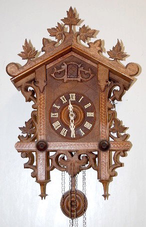 Black Forest Carved & Inlaid Cuckoo Clock: Black Forest Carved & Inlaid Cuckoo Clock: crest is carved leaves; face surround is inlaid strips; outer surround is carved leaves and scroll work; brass movement is not marked; has round pendulum and