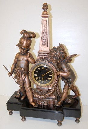 French Marble & Bronze Cherub Statue Clock: French Marble & Bronze Cherub Statue Clock: movement signed Blot & Drouard, Paris, E.D. 331; 8 day; time and strike; 1 cherub has on a Roman hat, holding a spear and clothed with a warp; the other has
