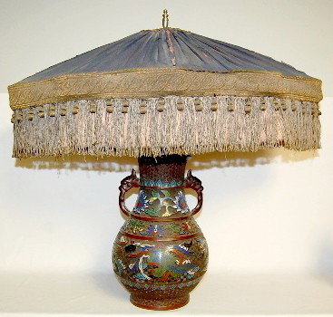 Bronze Oriental Champlevé Phoenix Table Lamp: - Bronze Oriental Champlevé Phoenix Table Lamp: not marked; bird head handles; floral and phoenix decoration with old fringed cloth shade. (Finial may have been replaced; shade is worn.) 22" All item