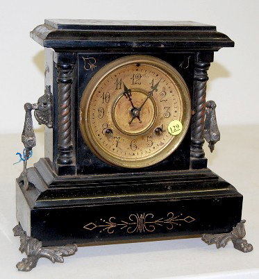 Iron Case "New Haven Mona Type" Mantle Clock: Iron Case "New Haven Mona Type" Mantle Clock: 8 day time and strike; hour and half hour gong strike; 4 1/2" unmarked metal dial; has pendulum; no key; black iron with cast metal trim and winged paw fe
