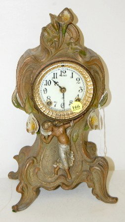 Ansonia "Lily" Metal Novelty Clock: Ansonia "Lily" Metal Novelty Clock: time and strike; 3" marked porcelain dial; has pendulum; no key; beveled glass; marked movement; not tested for running condition. (Some paint loss to case.) 13 1/2