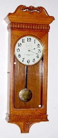 Oak American Clock Co. Antique Wall Clock: Oak American Clock Co. Antique Wall Clock: ornate carved oak case; w/ seconds bit; brass trim and pendulum; 11 1/2" metal dial. 52"*** Please note, this item is F.O.B. Marshalltown, IA, you must make