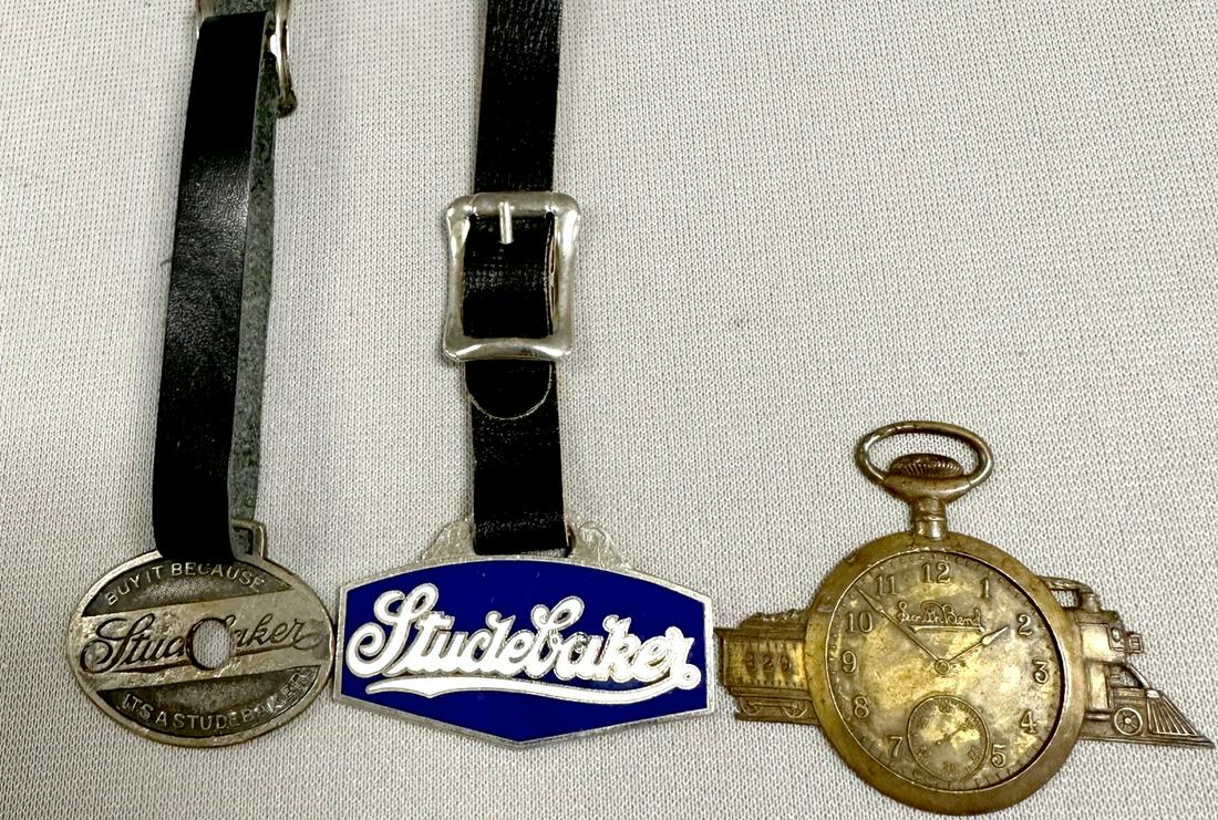 3 South Bend Watch Fobs: 3 South Bend Watch Fobs- The Studebaker 82 Studebaker. 1) old. Buy it now Studebaker Fob with a hole thru it. Made by Bastan Bros it is 1 1/4" x 1 1/2". 2) Enamel front with white word on blue. 1 1/4"