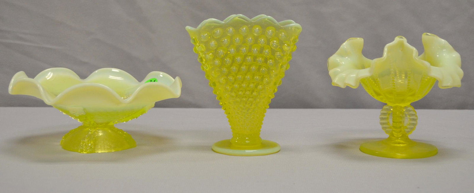 3 Vaseline Opalescant Glass Items: 3 Vaseline Opalescant Glass Items. 1) Small, flares dish. 3 1/4"T x 7 1/2" W. 2) small dish with Tri roll rim. 5"T x 5 3/4" W. 3) Hobnail fun vase 5 3/4"T x 5" W.