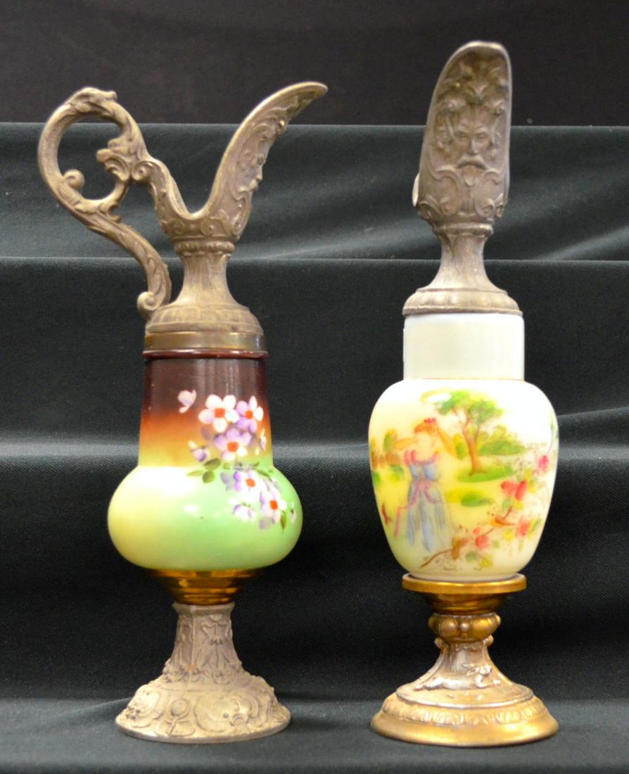 2 Antique Ewers: 2 Antique Ewers. The tops are metal and match. The milk glass bodies and metal foot do not match. They are 12 1/2" tall. One may have been built with off pieces.