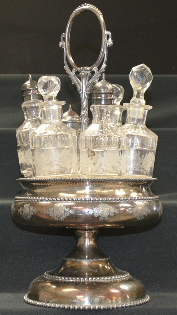 6 Bottle Caster Set: 6 Bottle Caster Set with stoppers and original fixtures. Set in a nice No. 131 Rugers silver plate holder. 15 1/2"T. One Stopper a replacement